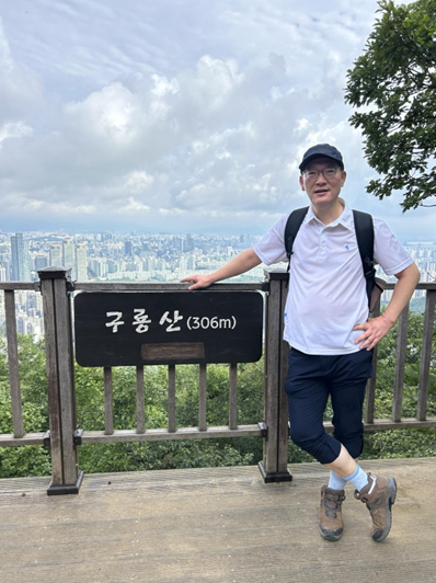 Jong-Kwon Lim standing on a hill behind his company
