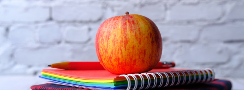 apple sitting on top of notebooks