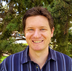 A person smiling in front of a tree  AI-generated content may be incorrect.