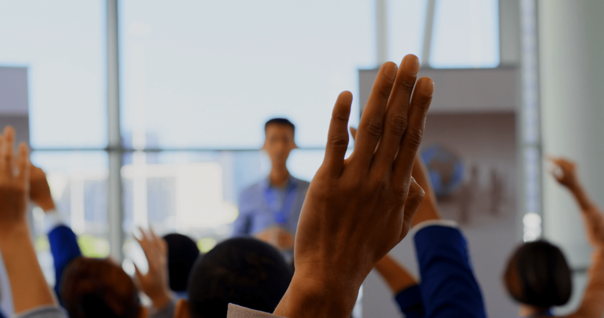 hand is raised during a professional team meeting discussing leadership development and business strategy