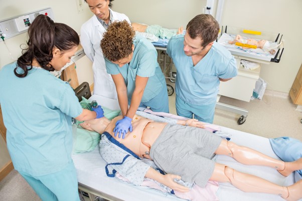 decorative image of healthcare students in a simulation lab