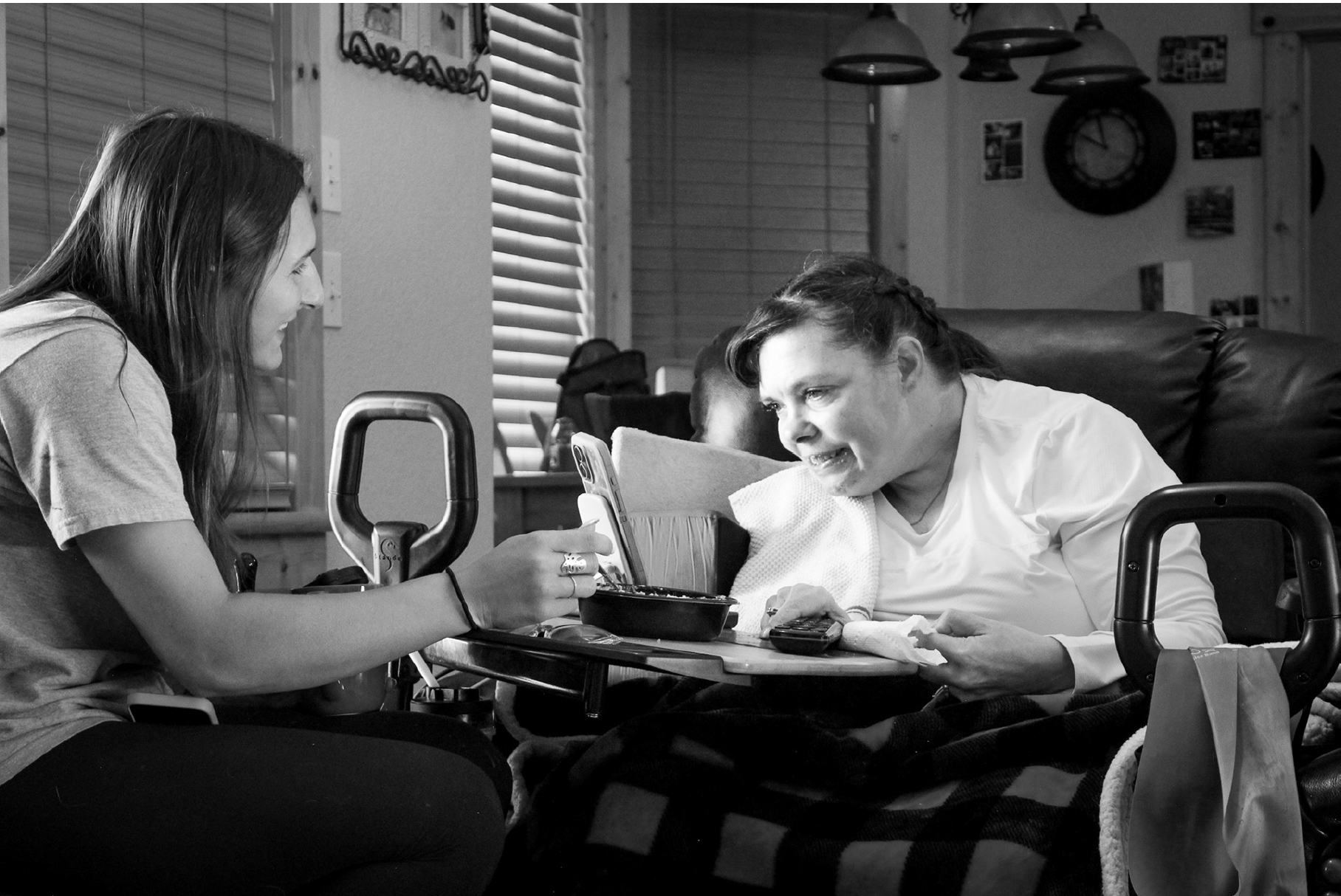 A caregiver helps a woman eat her breakfast.
