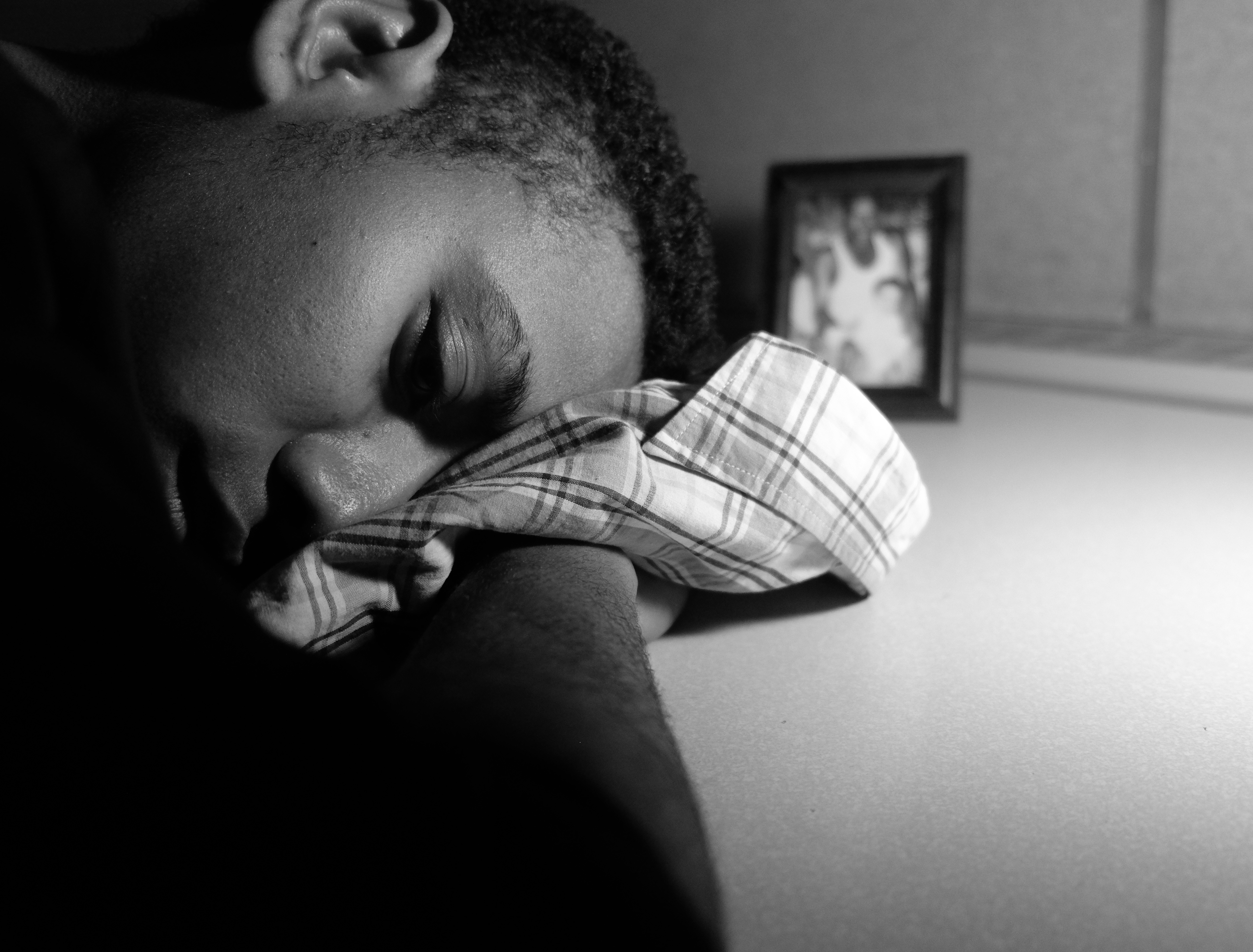 A woman rests her head on a shirt belonging to her father.