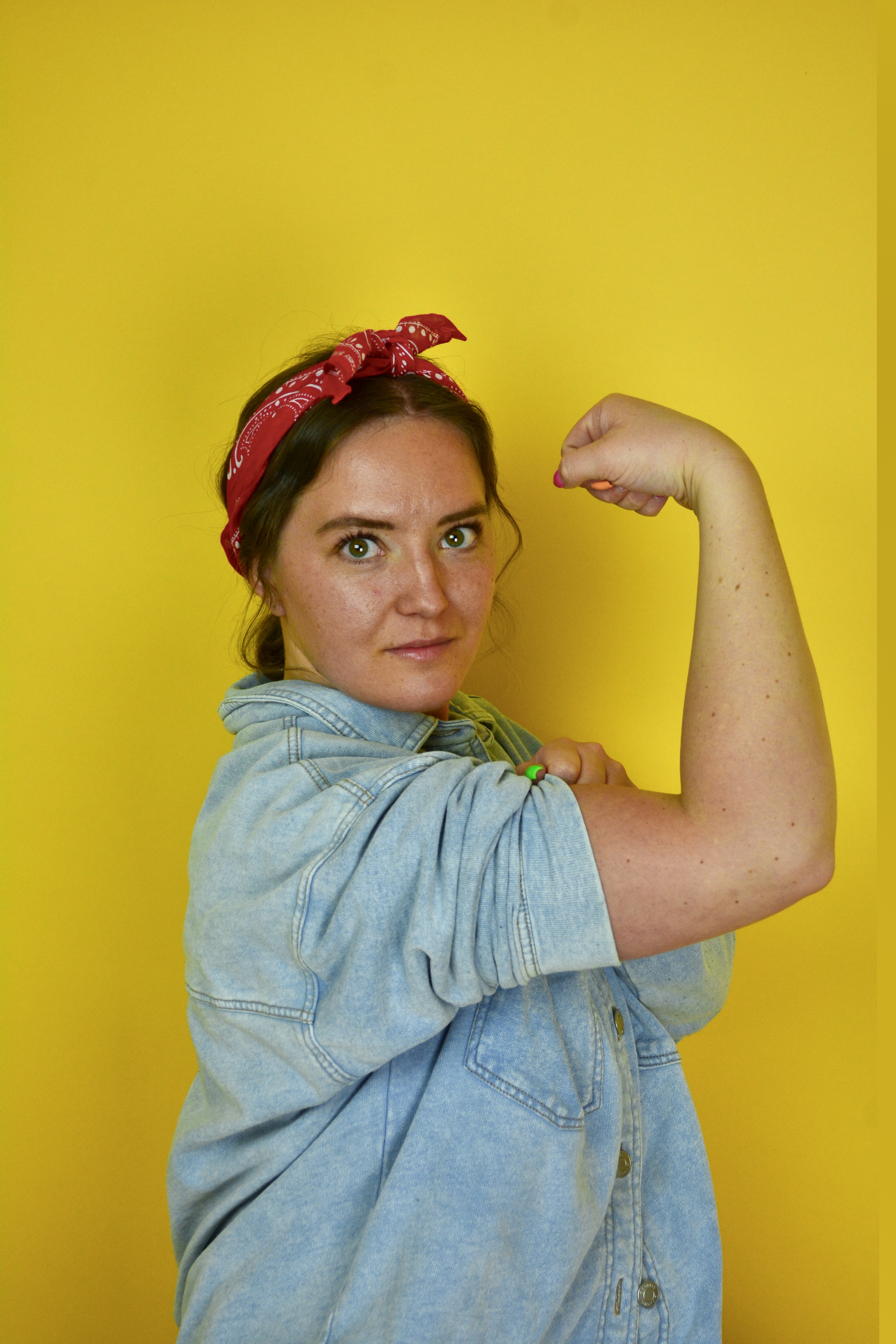A woman flexes her bicep in a photographic tribute to J. Howard Miller's iconic 1943 