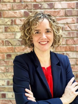 A person with curly hair wearing a suit and red shirt

AI-generated content may be incorrect.