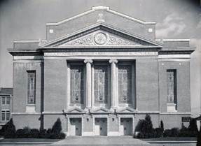 A large brick building with columns

AI-generated content may be incorrect.