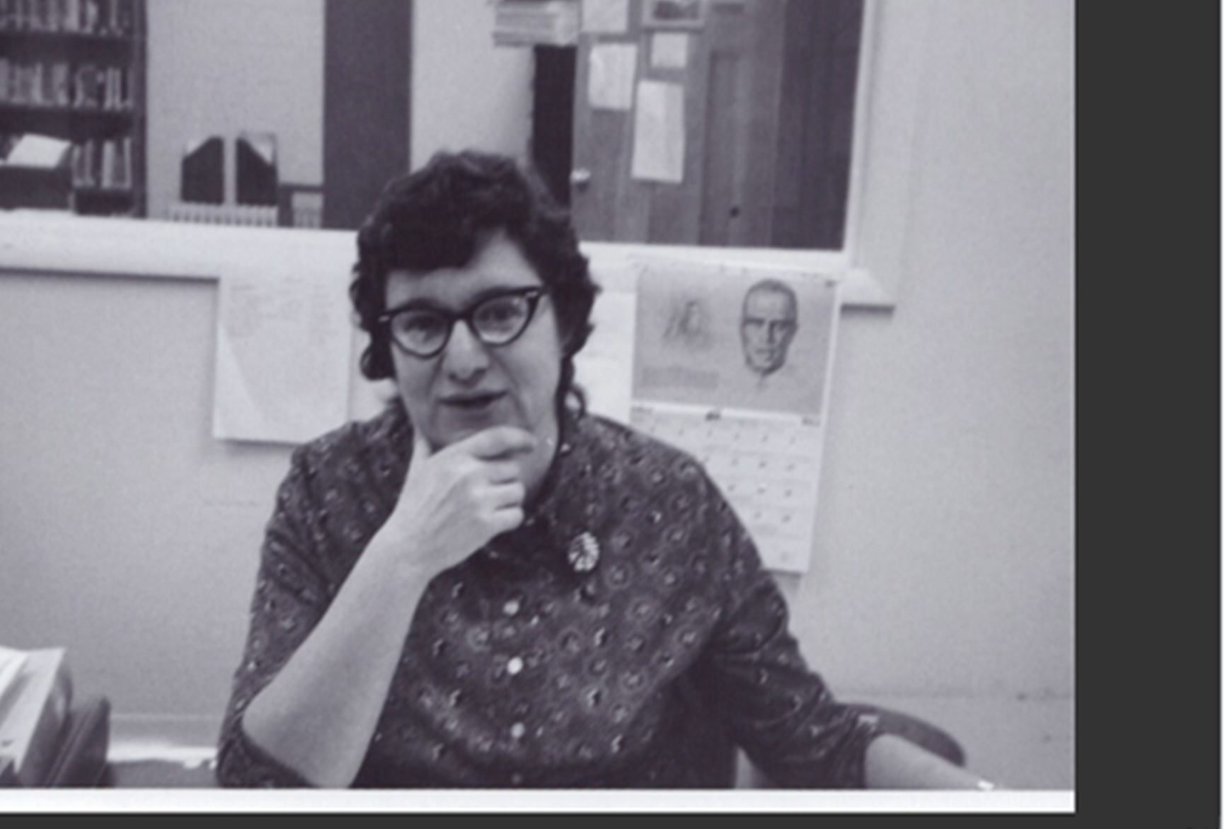 woman in a library, hand on chin