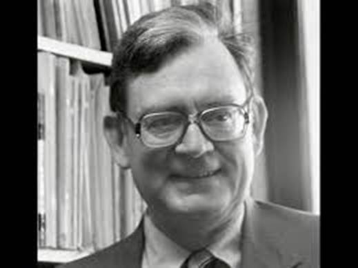 man smiling against backdrop of books