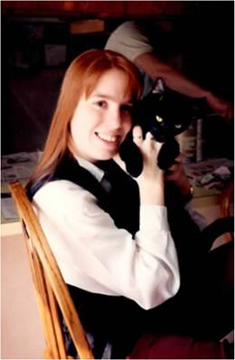 a woman holding a cat and smiling
