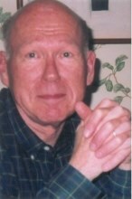 A close-up of a man with hands crossed.