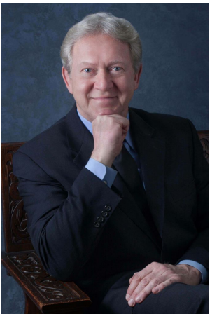 man posed, smiling and hand under chin