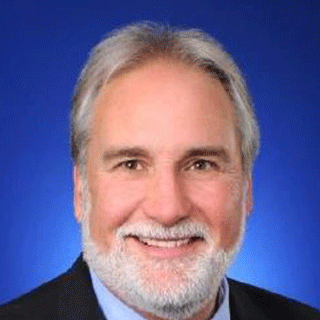 a man with a grey beard smiles