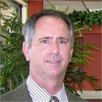 a man with a tan suit smiling