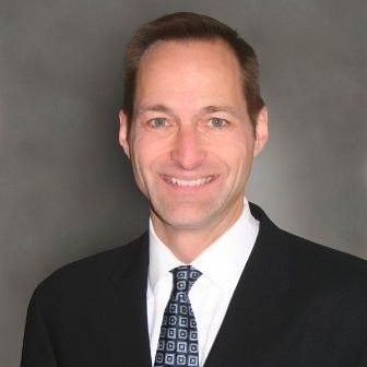 A brown haired man wearing a suit and tie