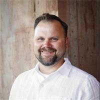 a man in a white collar shirt smiles