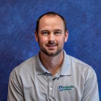 a man with a grey shirt smiles
