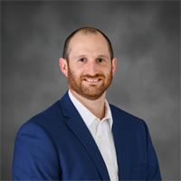 man in a blue blazer smiling