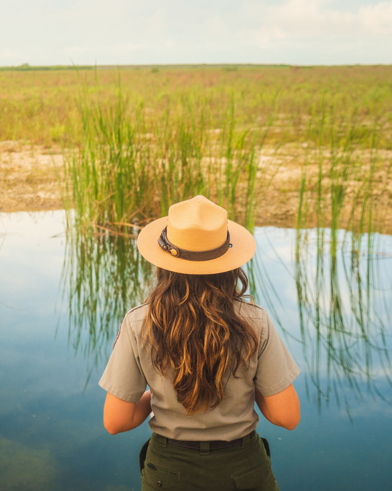 female park ranger overlooking a lake