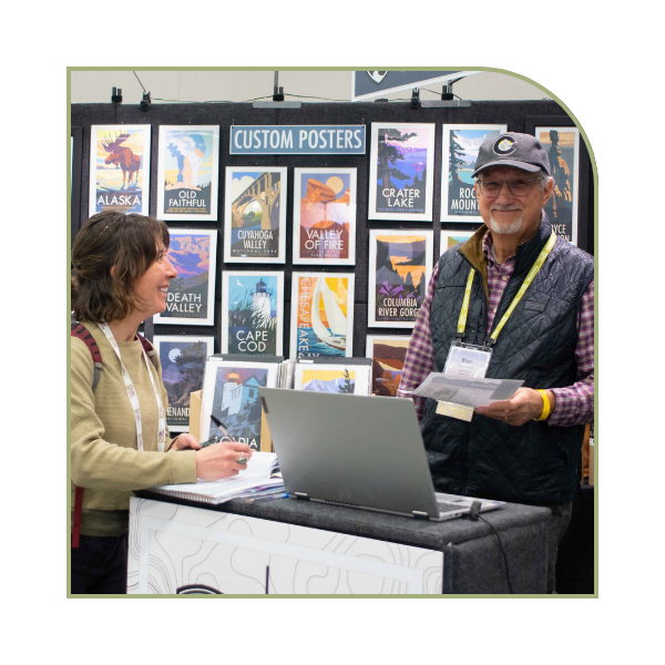two people at a vendor booth completing a deal