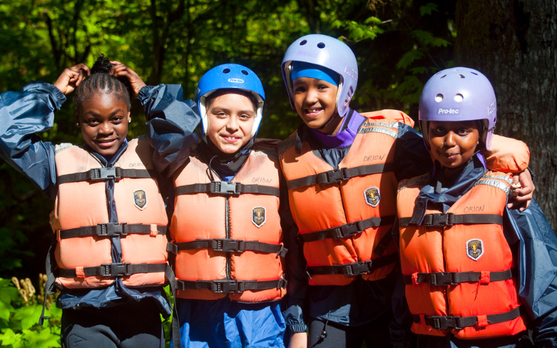 four young girls in life jackets