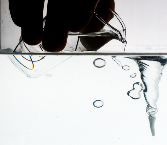 Antibubbles are about to born. Soapy water is poured from a Bécher into a soapy water pool. Air is entrained (dark regions below the pool surface)10 mm