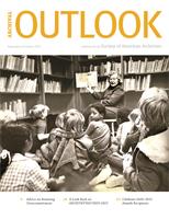 A young Black boy looks back at the camera during a group read in a library.