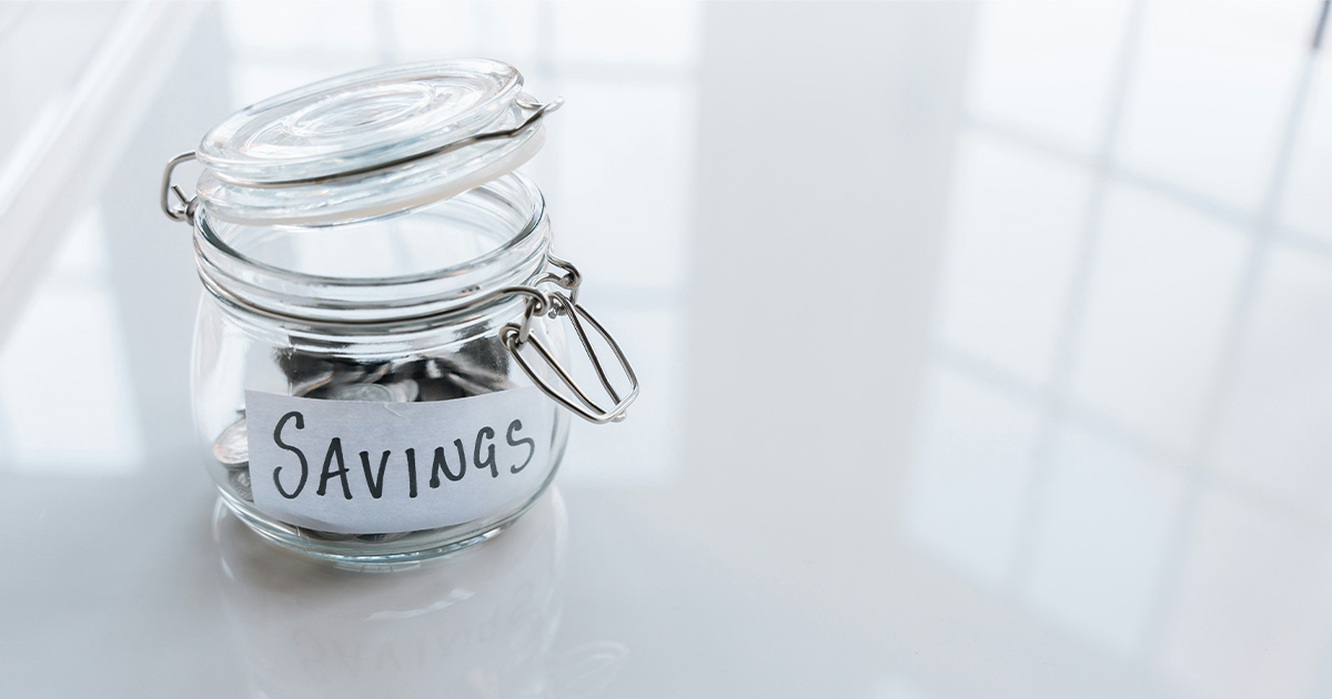 Glass jar labeled “savings” representing healthcare cost reduction and financial efficiency
