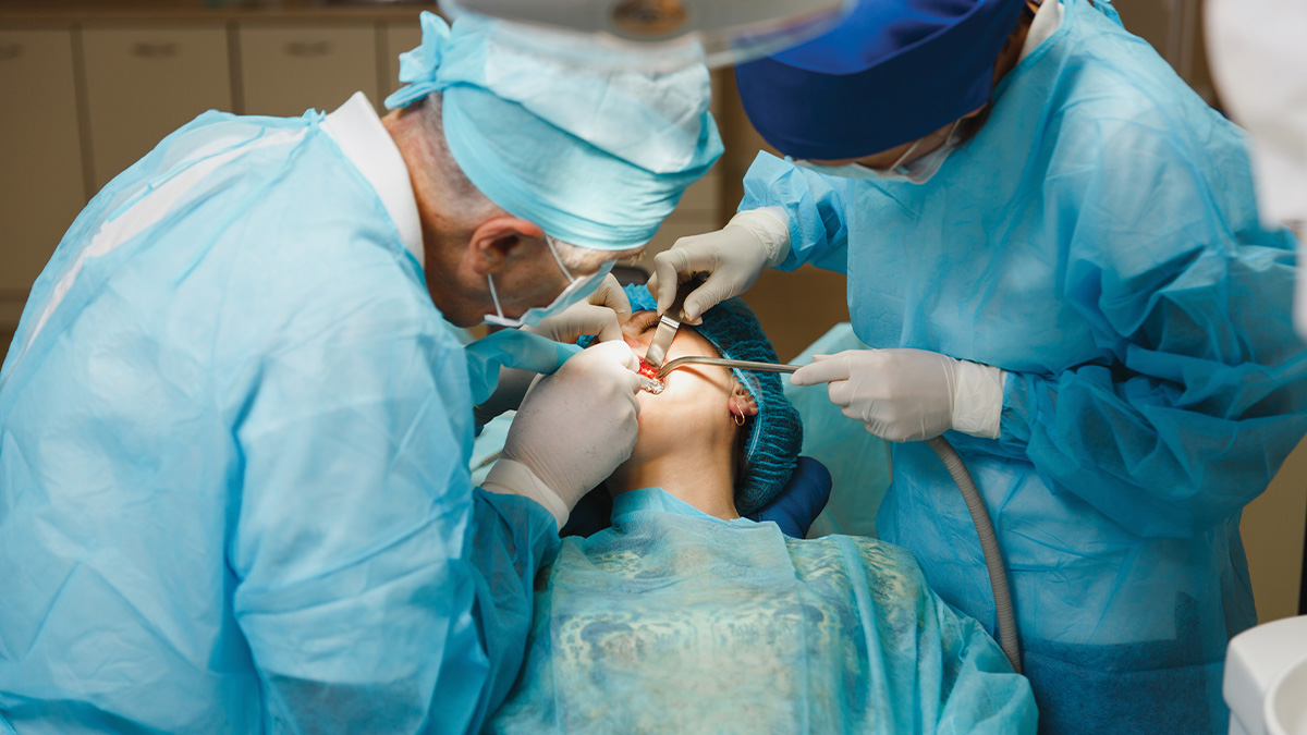 Two dental professionals working on a patient.