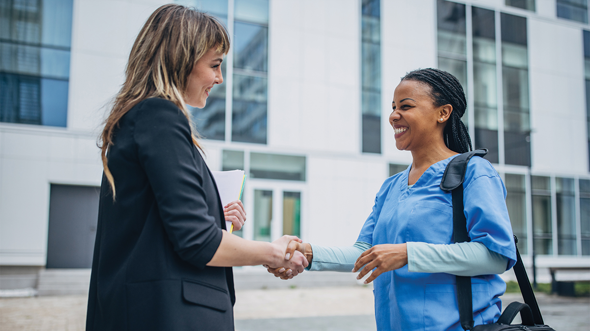 Two women shaking hands.
