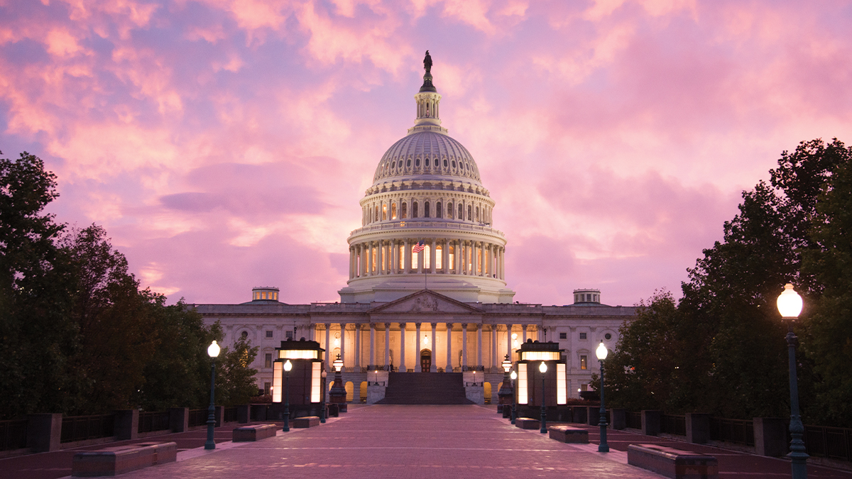 The Capitol Building backlit by a pink dusk.