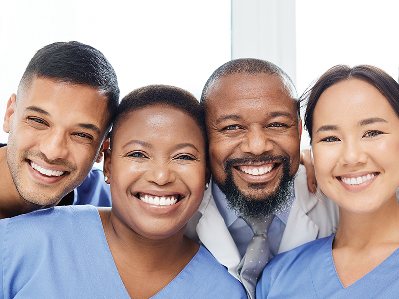 Four medical professionals smiling at the camera.