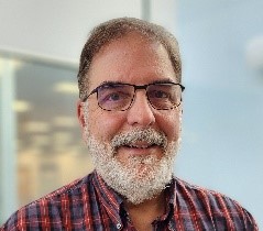 A person with a beard and glasses

Description automatically generated