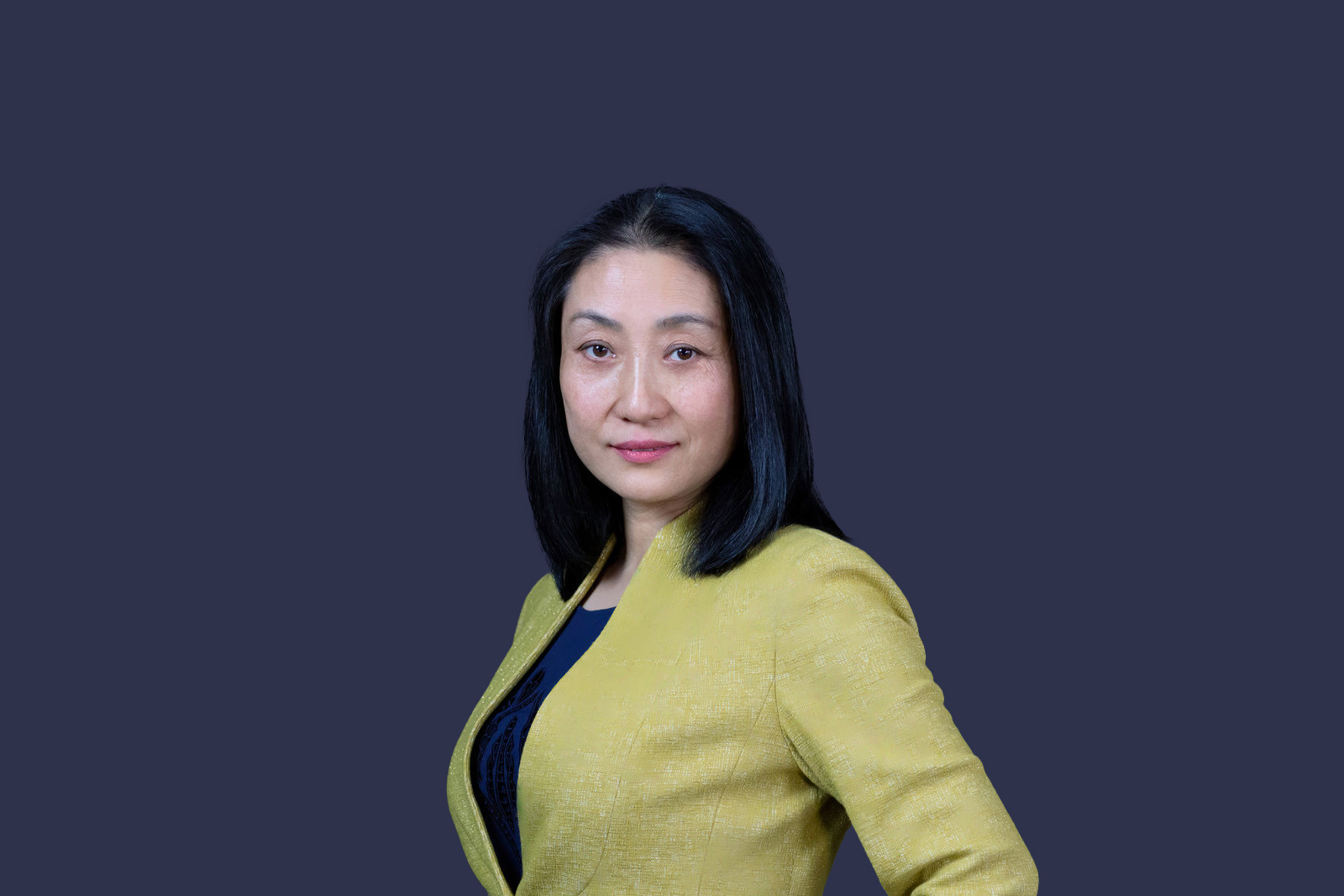A person with dark hair wearing a yellow jacket

Description automatically generated