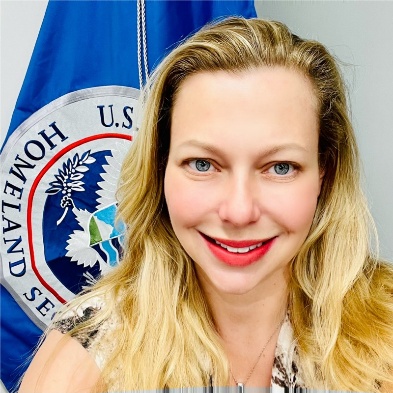 A person smiling in front of a flag

AI-generated content may be incorrect.