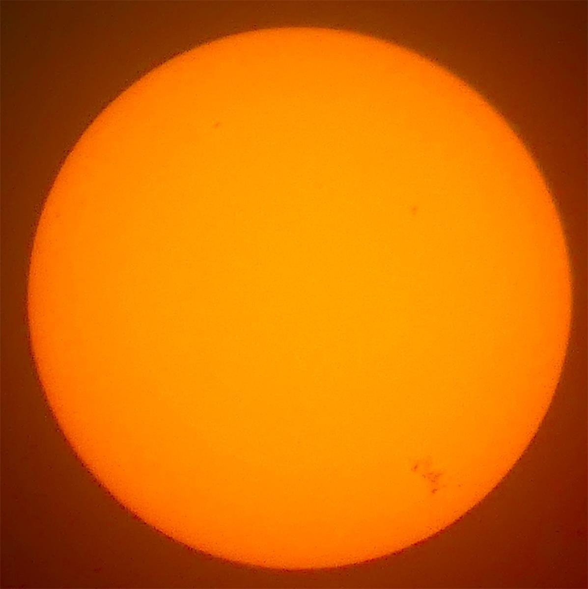 This photo was taken using eclipse glasses from 2017 and shows the sunspot that caused the northern lights outbreak in the bottom right hand corner