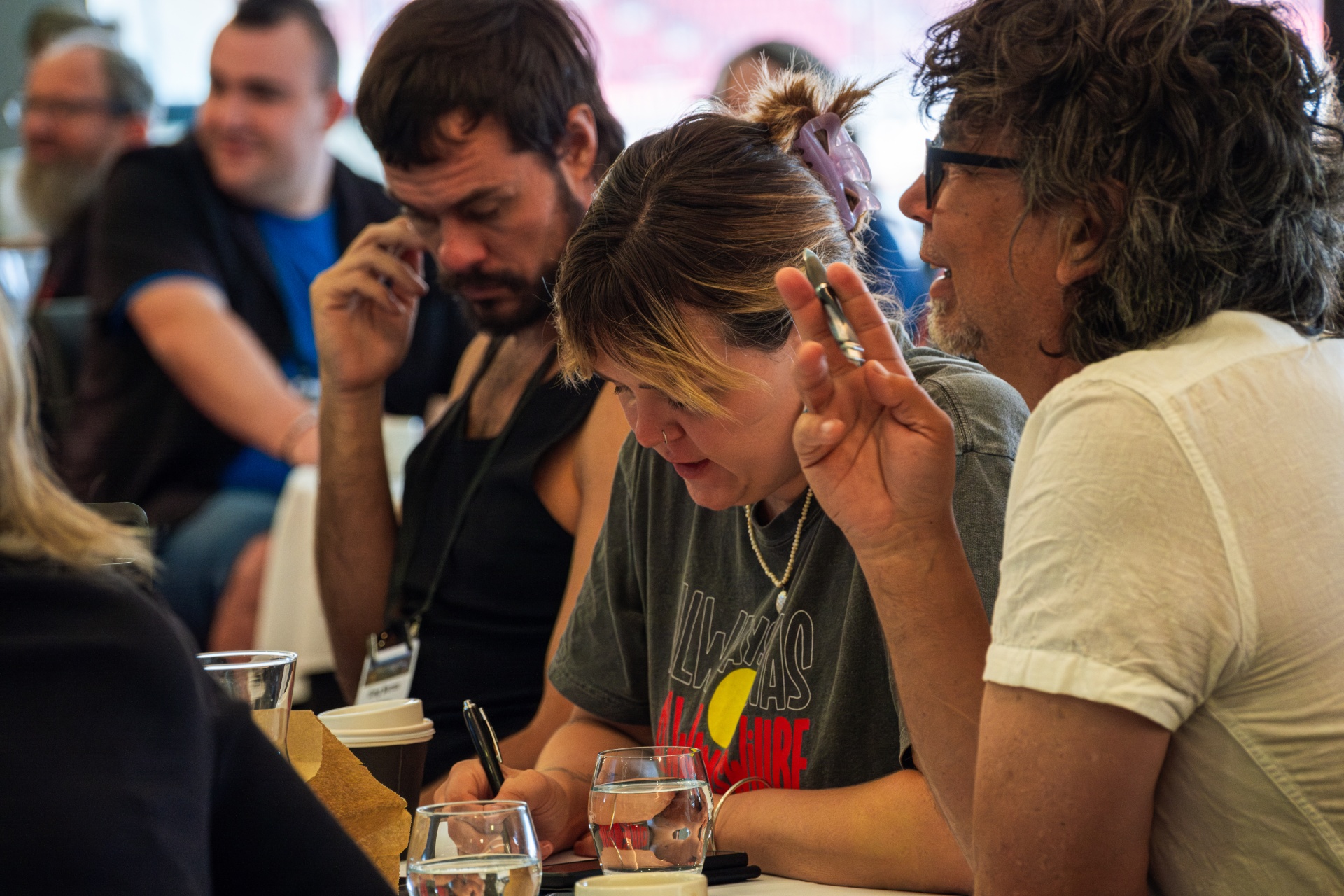 Three people sitting at desks during CBAA Conference
