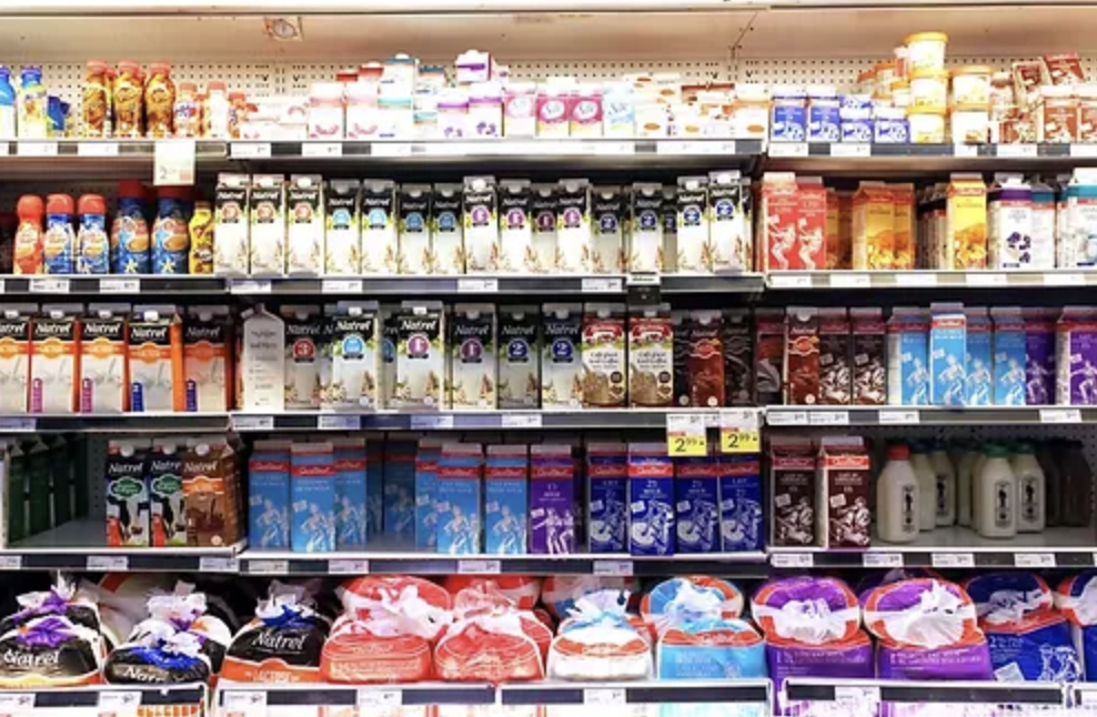 Grocery store fridge full of milk and milk alternatives.