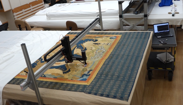 Fotonowy bridge setup over art (MMA.15.95.154) The bridge-type MFT stand developed by and now available from Instytut Fotonowy for The Metropolitan Museum of Art Department of Textile Conservation, pictured in use on a Qing dynasty temple wall hanging (MMA.15.95.154)