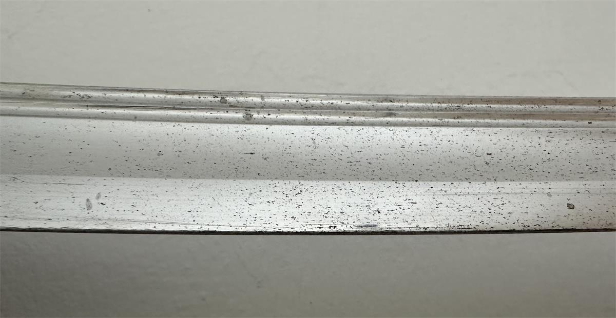 The detail of the nickel-plated sword blade showing the signs of corrosion.