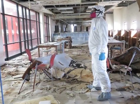 Responder in PPE assesses damage