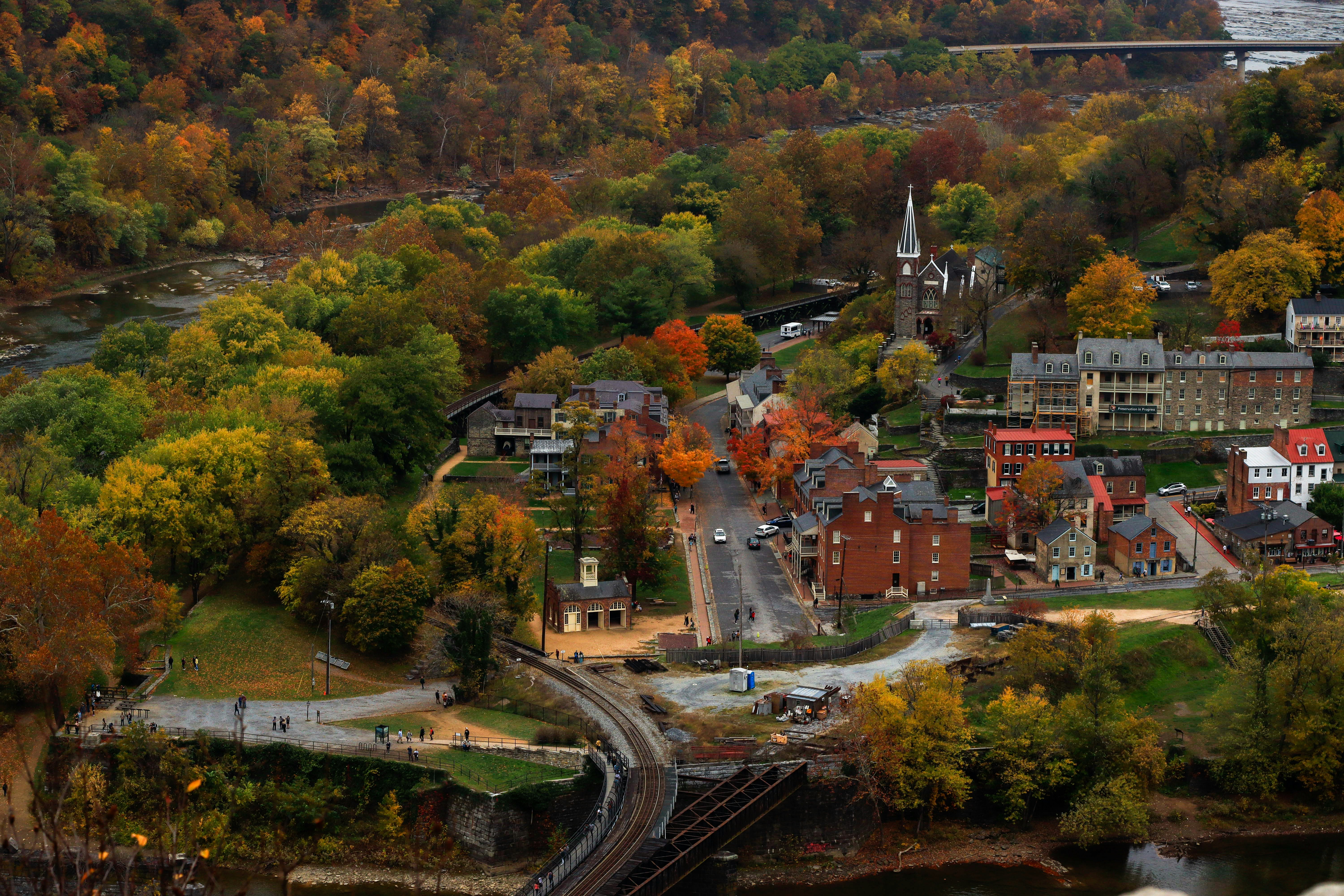 Buildings along highway surrounded by trees in fall color