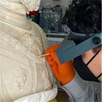 Image of person with magnifiers working on sculpture