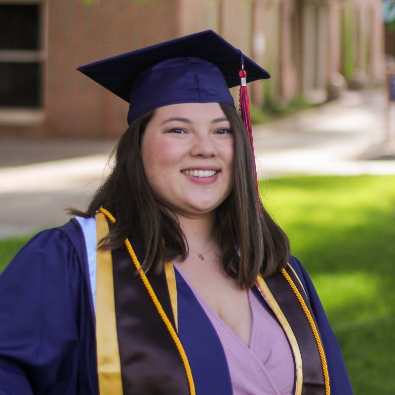 Photo of a woman with long dark wavy hair and glasses