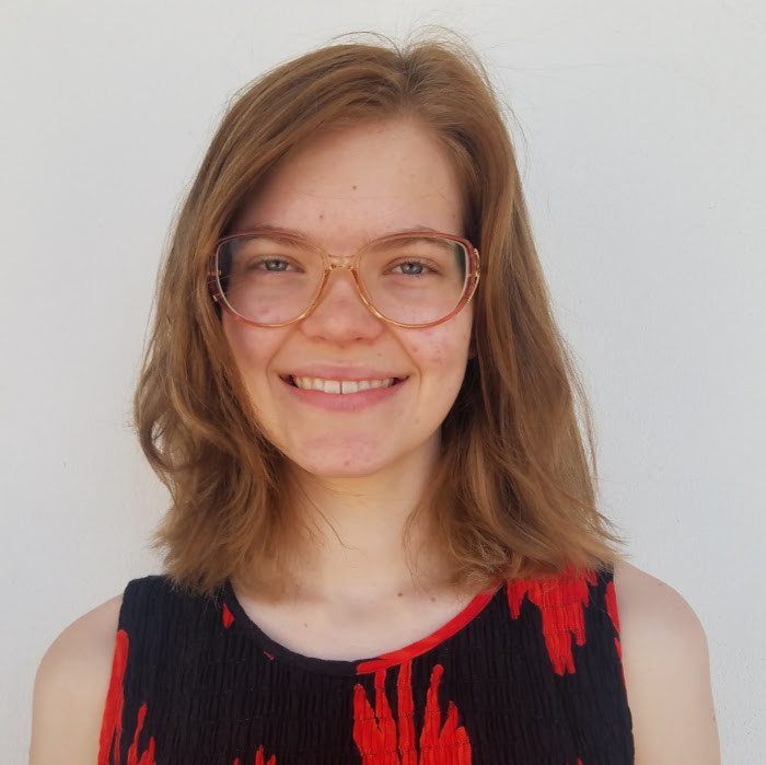 Image of a woman wearing glasses and a red and black shirt