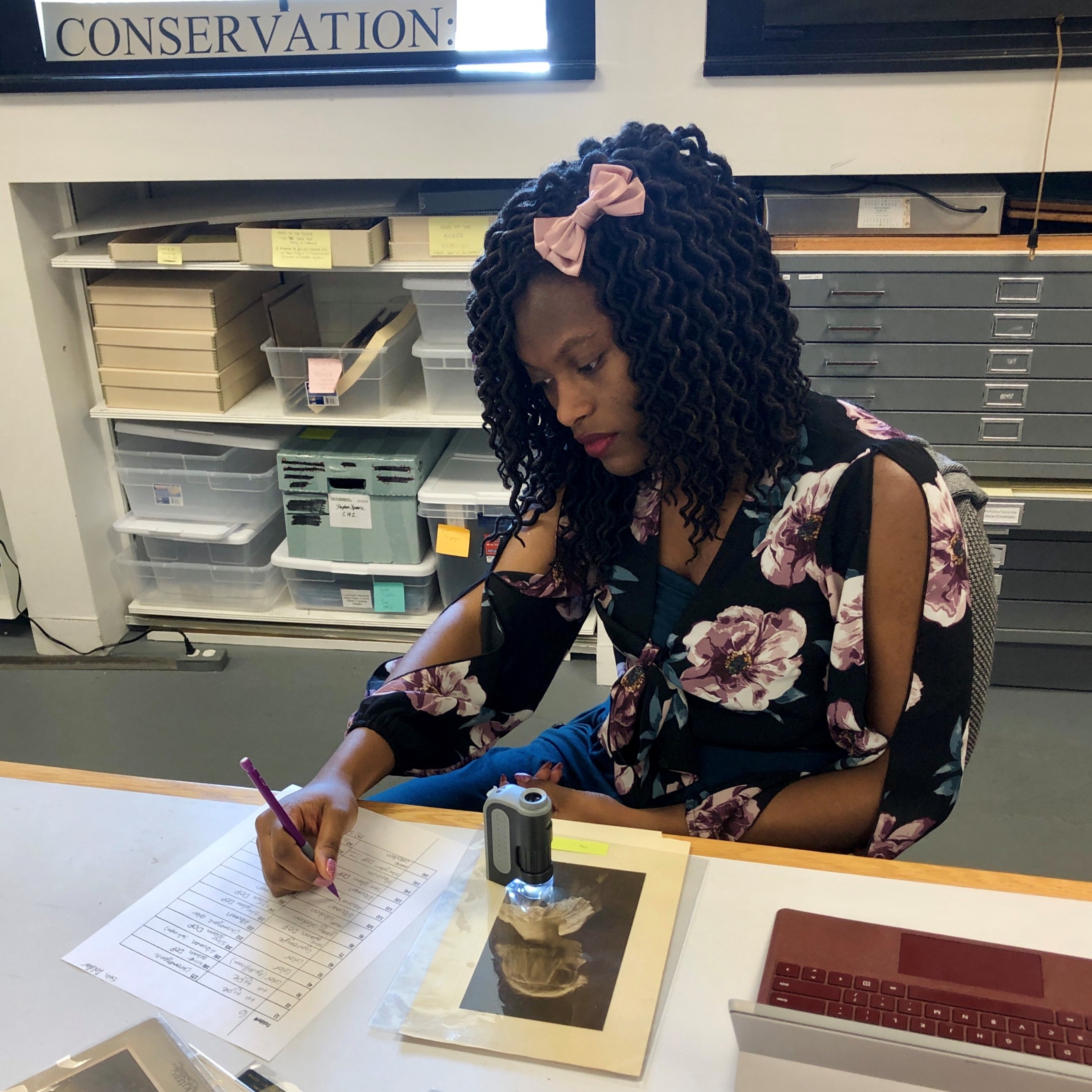 Member Nylah Byrd investigates a work on paper and takes notes
