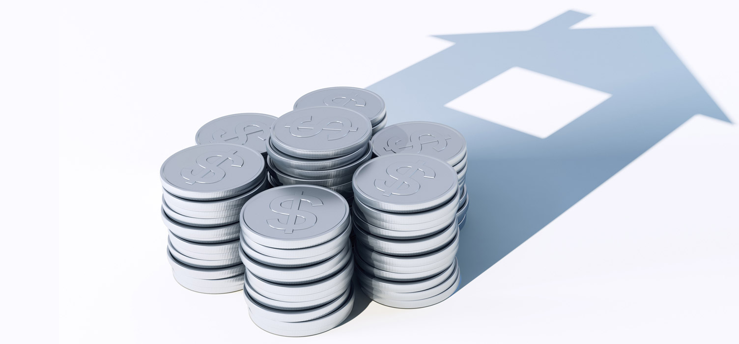 stacked money casting shadow of a house