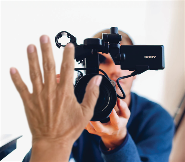 holding hand up to block camera lens