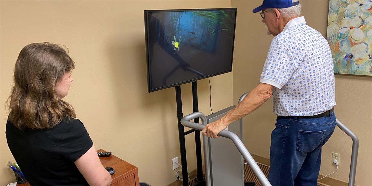 senior citizen on balance platform watching video screen
