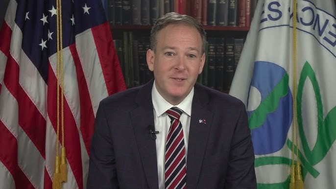 Man speaking with US and EPA flags behind him