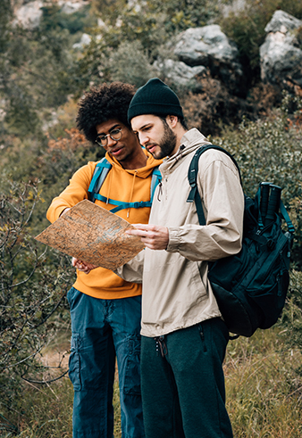 Photo of one person helping another read a map.